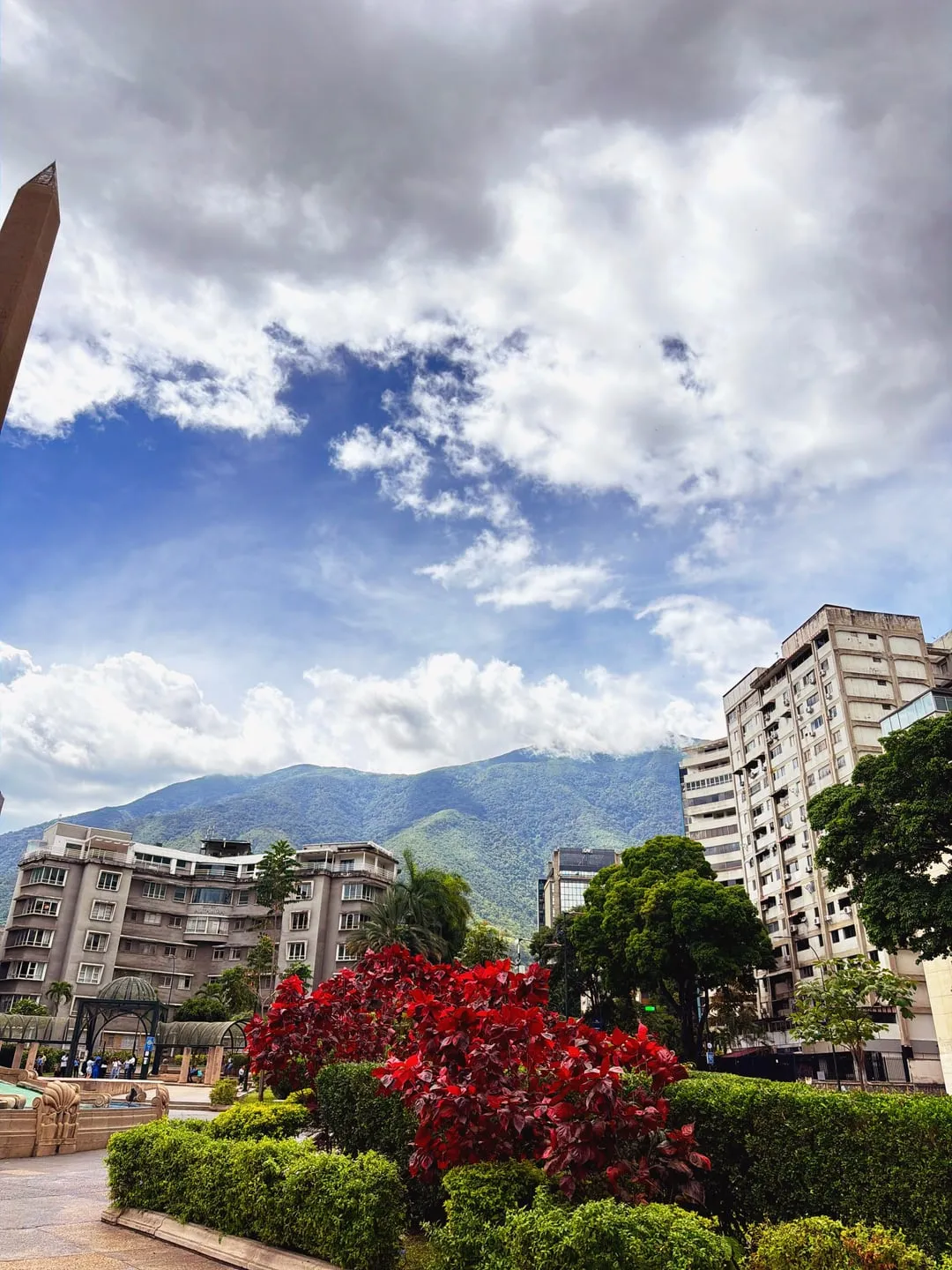 Apartment buildings, red shrubs and mountains under clouds, shot with Nōma's Khrome recipe